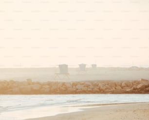 a couple of chairs sitting on top of a beach next to the ocean