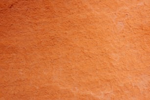 a close up of a red wall with a clock on it