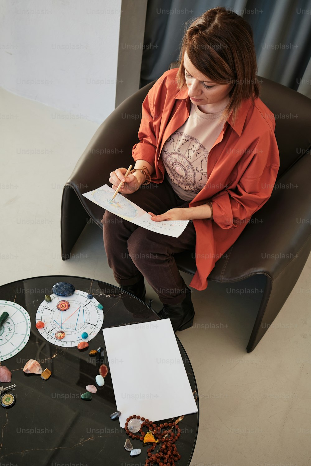 a woman sitting in a chair writing on a piece of paper