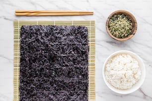 a bowl of rice next to a bowl of rice and chopsticks