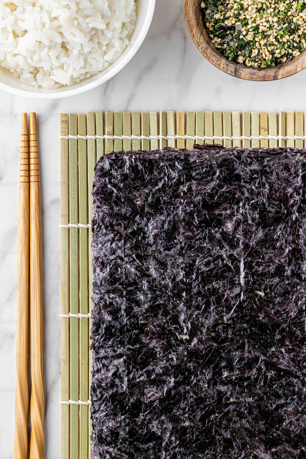 Premium Photo  Seaweed sushi on bamboo mat chopsticks on table