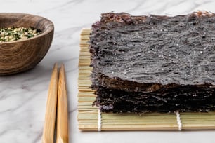 a table topped with chopsticks next to a bowl of food