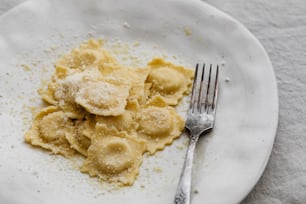 a white plate topped with pasta and a fork