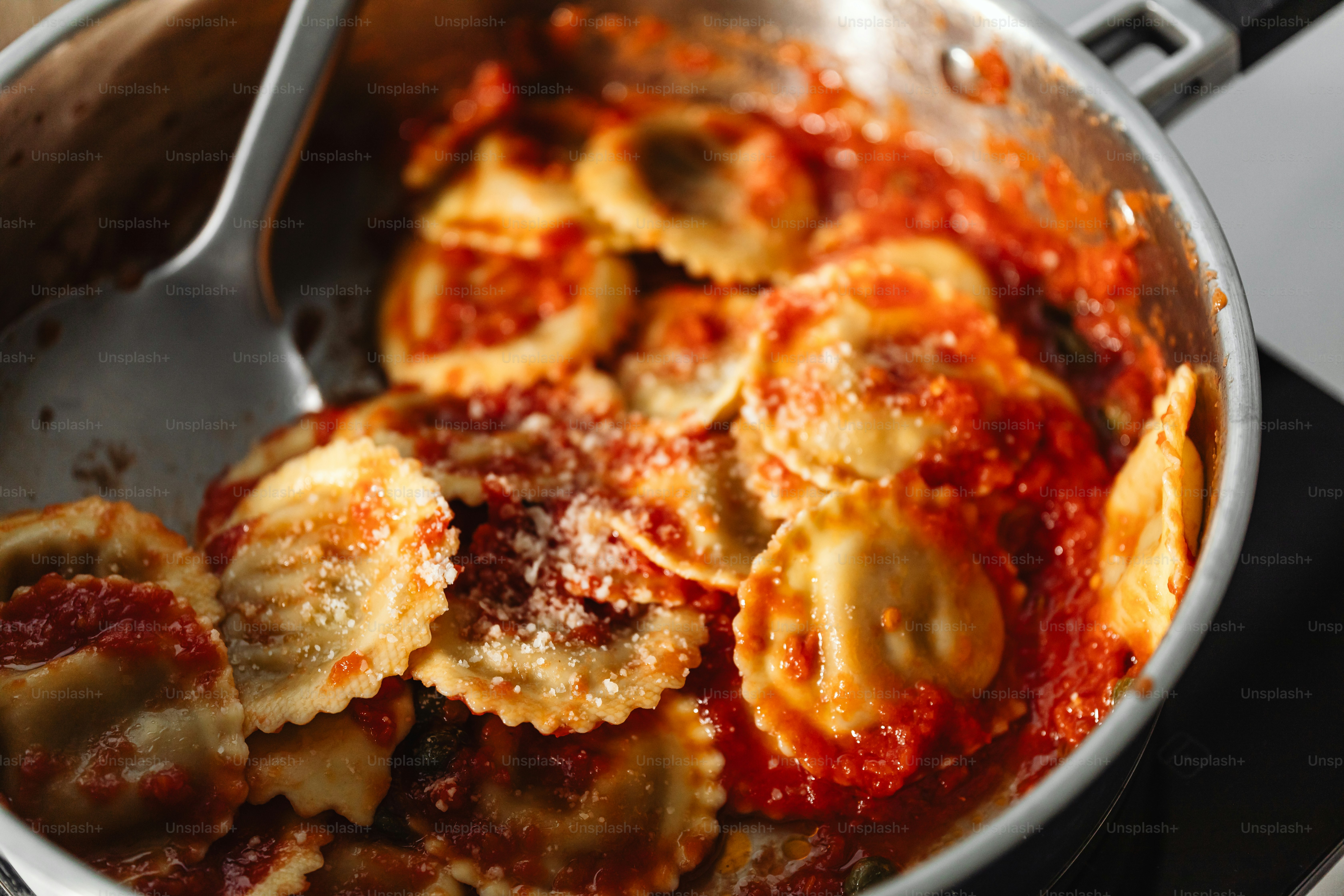 wajan berisi ravioli dan saus di atas kompor