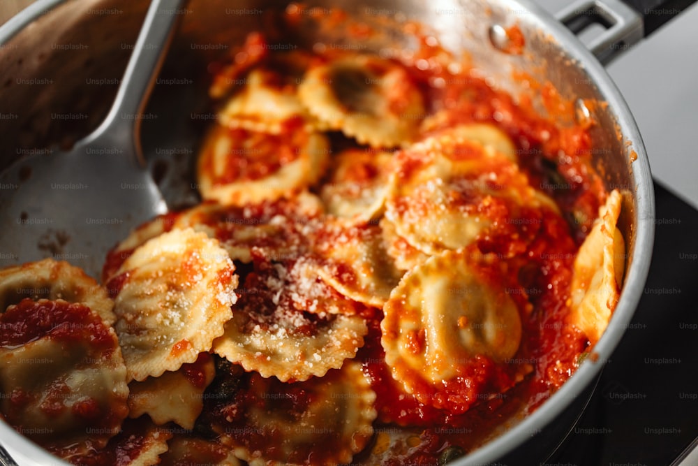 a pan filled with ravioli and sauce on a stove