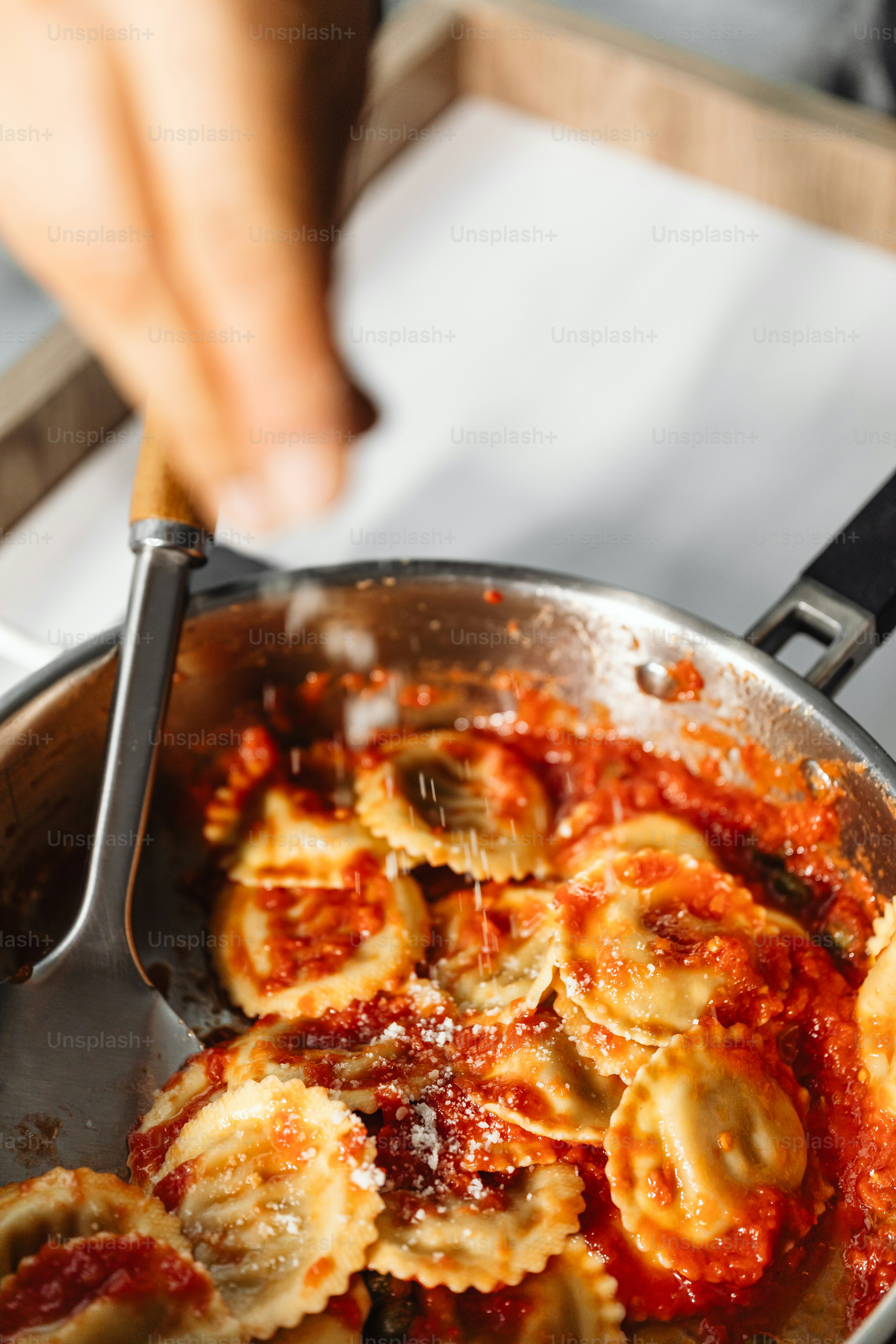 une poêle de pâtes avec de la sauce remuée avec une cuillère