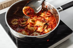 a pot of pasta being stirred with a ladle