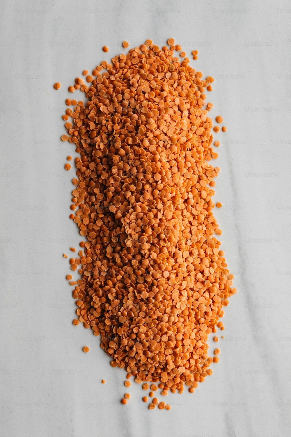 uma pilha de sementes de laranja sentada em cima de uma mesa branca