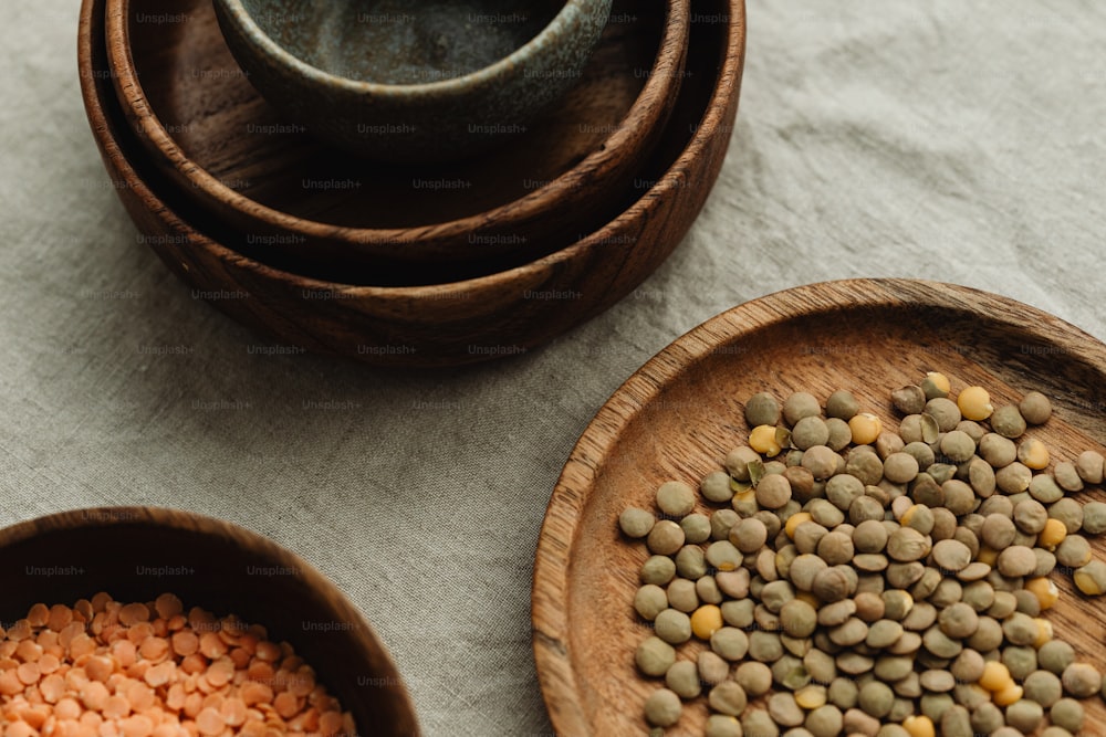 a wooden bowl filled with lentils next to a wooden bowl filled with lentils