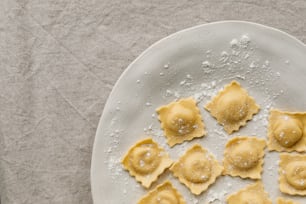 a plate of ravioli with powdered sugar on top
