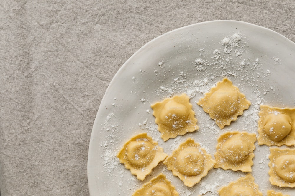 a plate of ravioli with powdered sugar on top