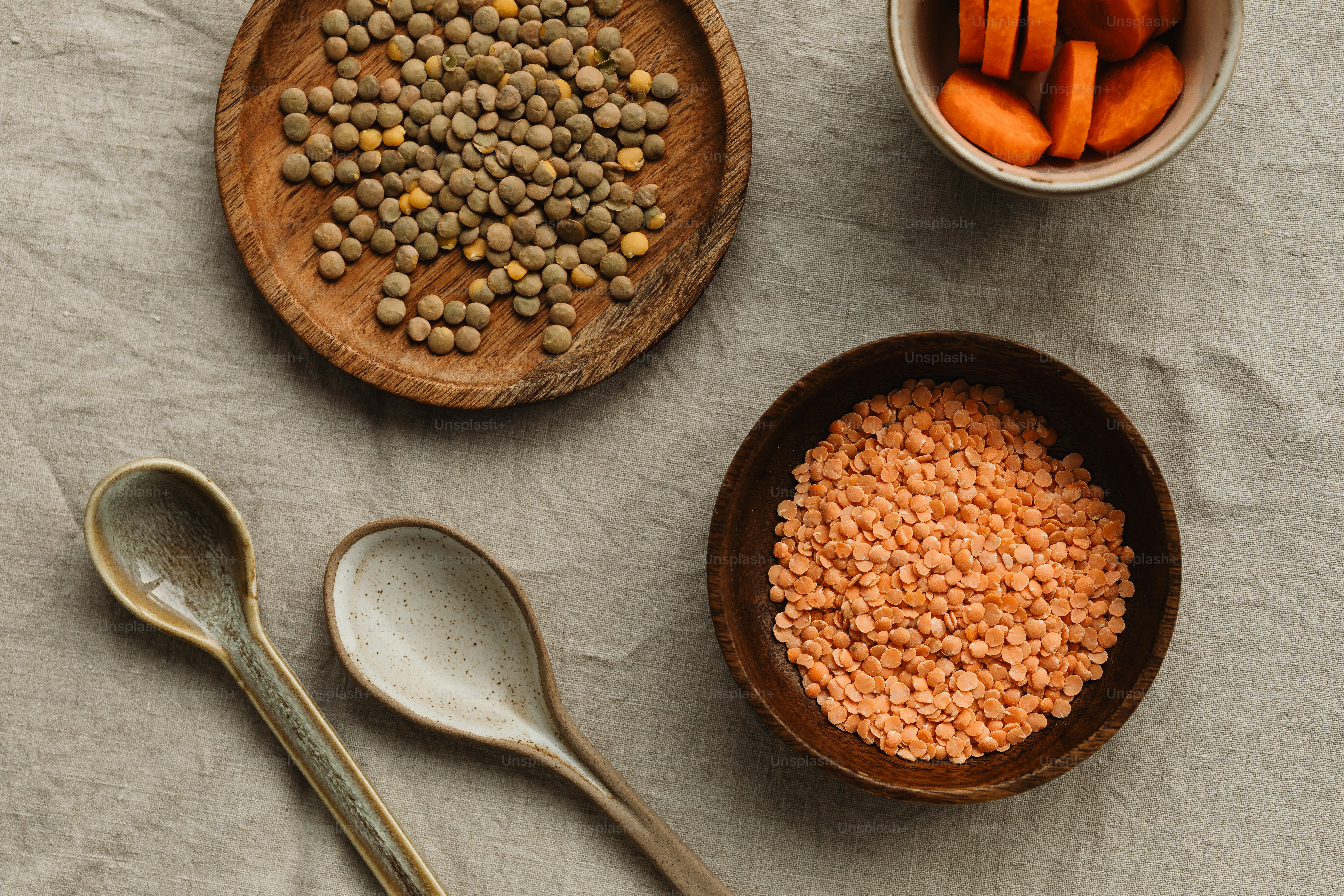 a table topped with bowls of beans and carrots