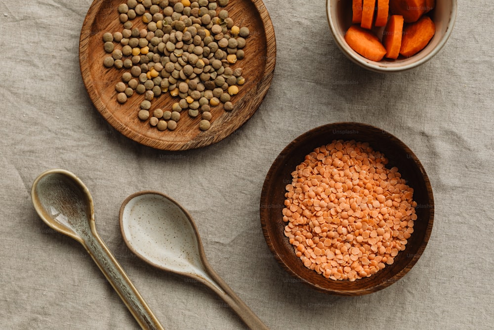 a table topped with bowls of beans and carrots