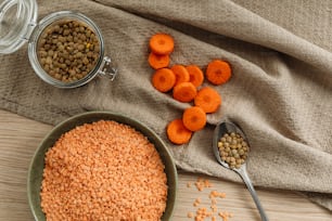 una ciotola di lenticchie, carote e piselli su un tavolo