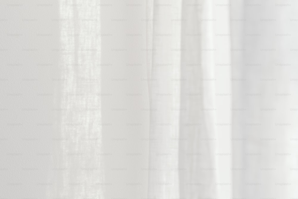 a close up of a white curtain with a white background