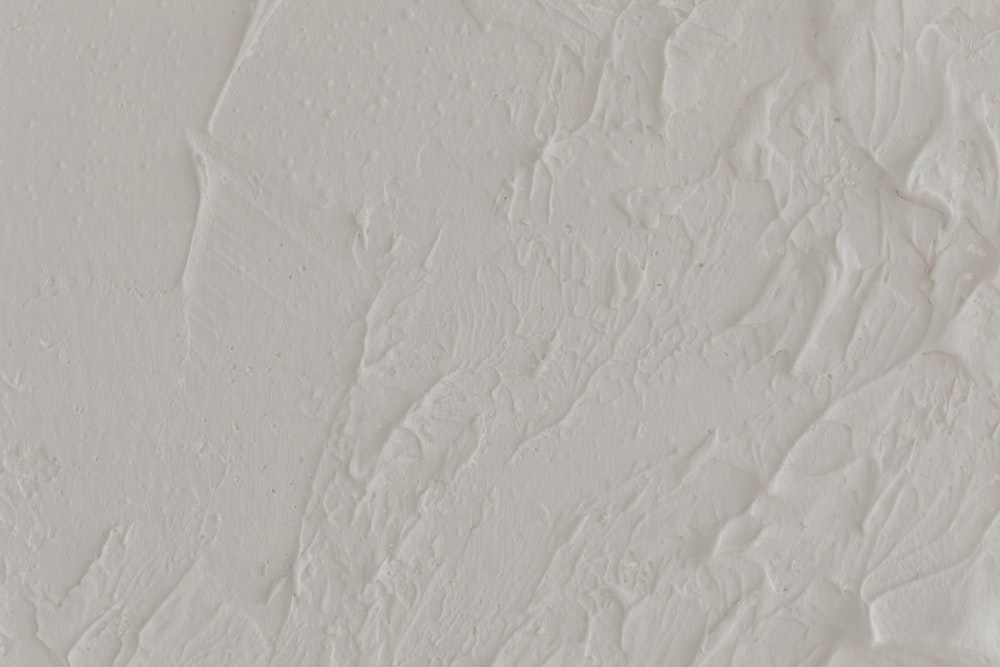un primo piano di un muro con vernice bianca