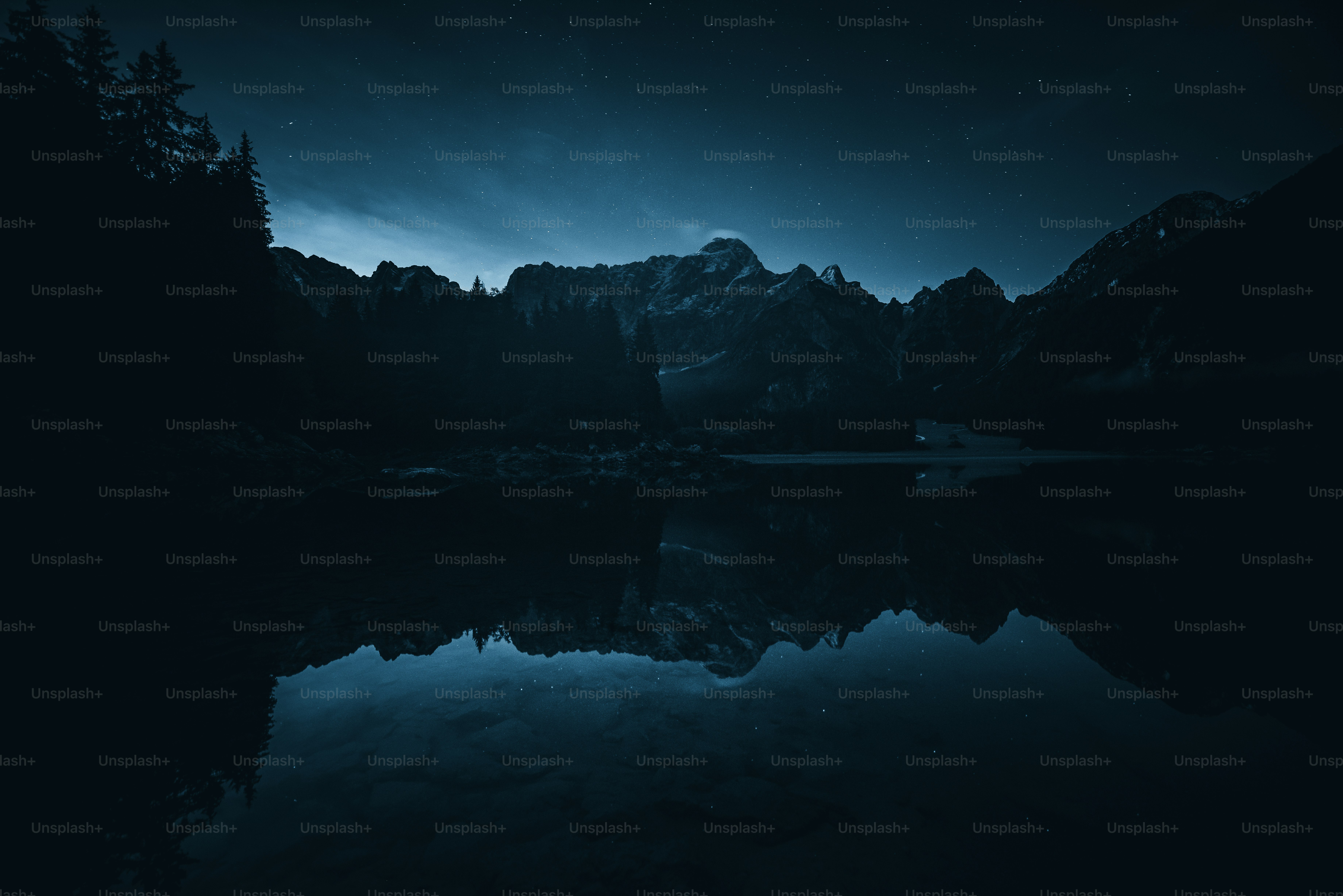 a mountain range with a lake in the foreground
