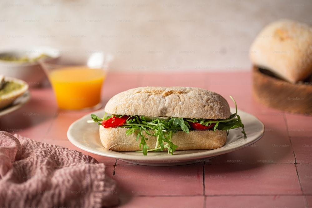 un sandwich avec de la laitue et des tomates dans une assiette