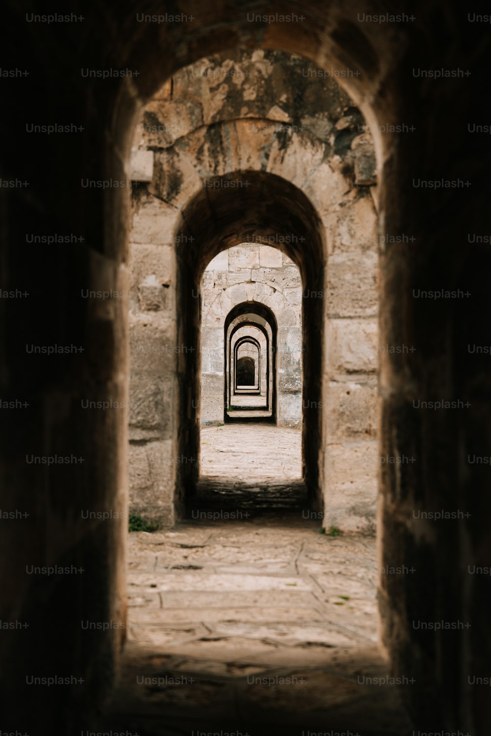 un tunnel dans un mur de pierre avec une lumière au bout