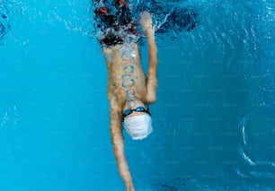 a man swimming in a pool with a mask on his face