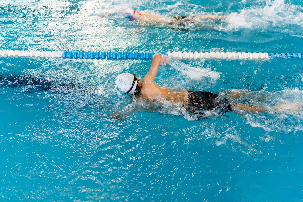 un hombre nadando en una piscina con un sombrero puesto