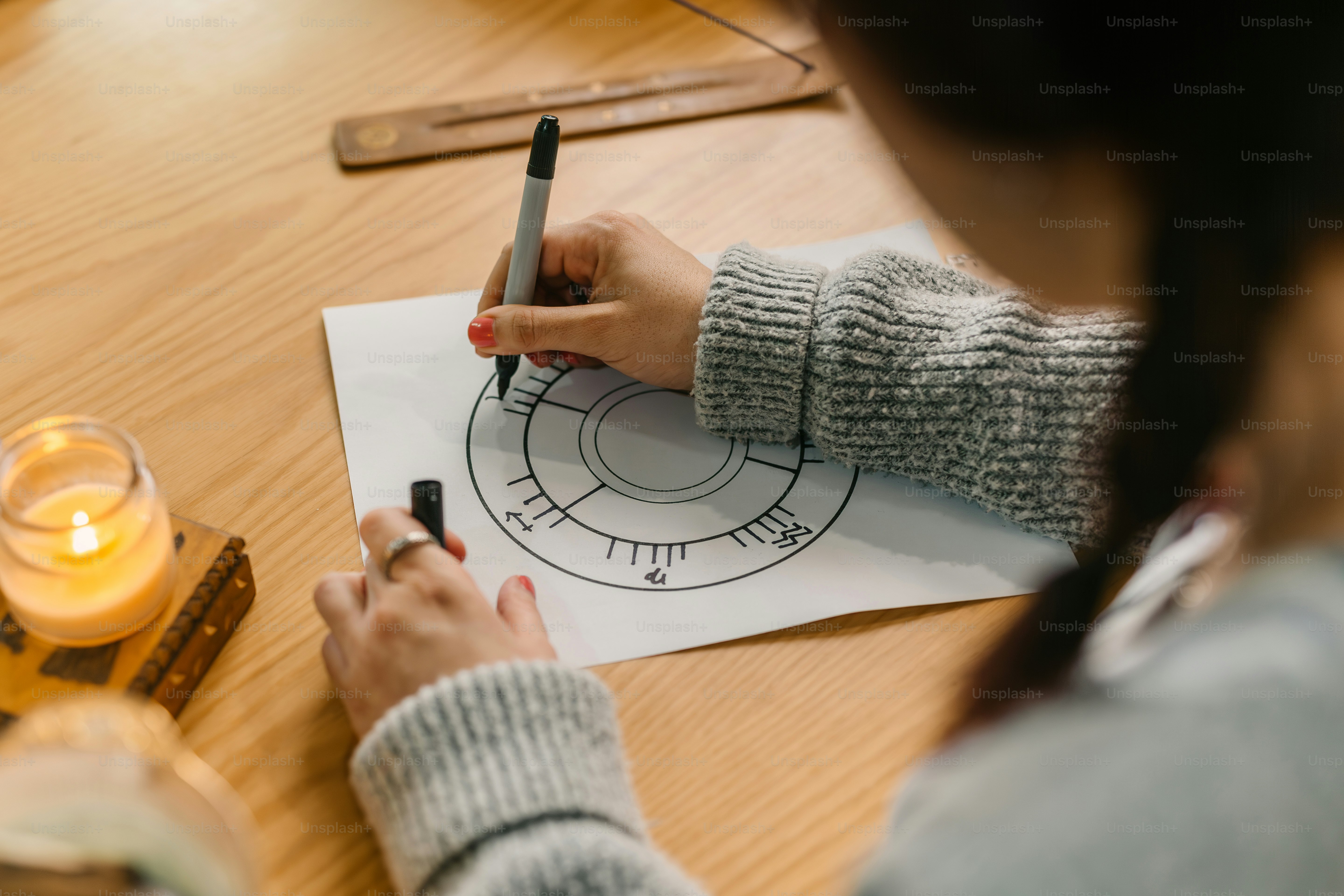 a person sitting at a table writing on a piece of paper