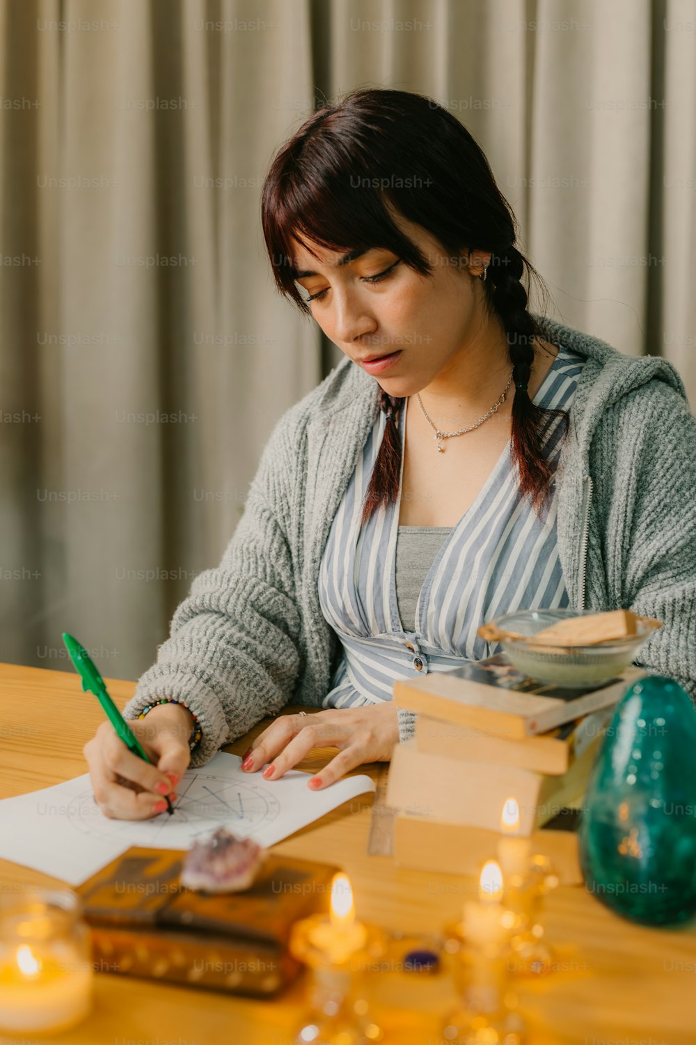 eine Frau sitzt an einem Tisch und schreibt auf ein Blatt Papier