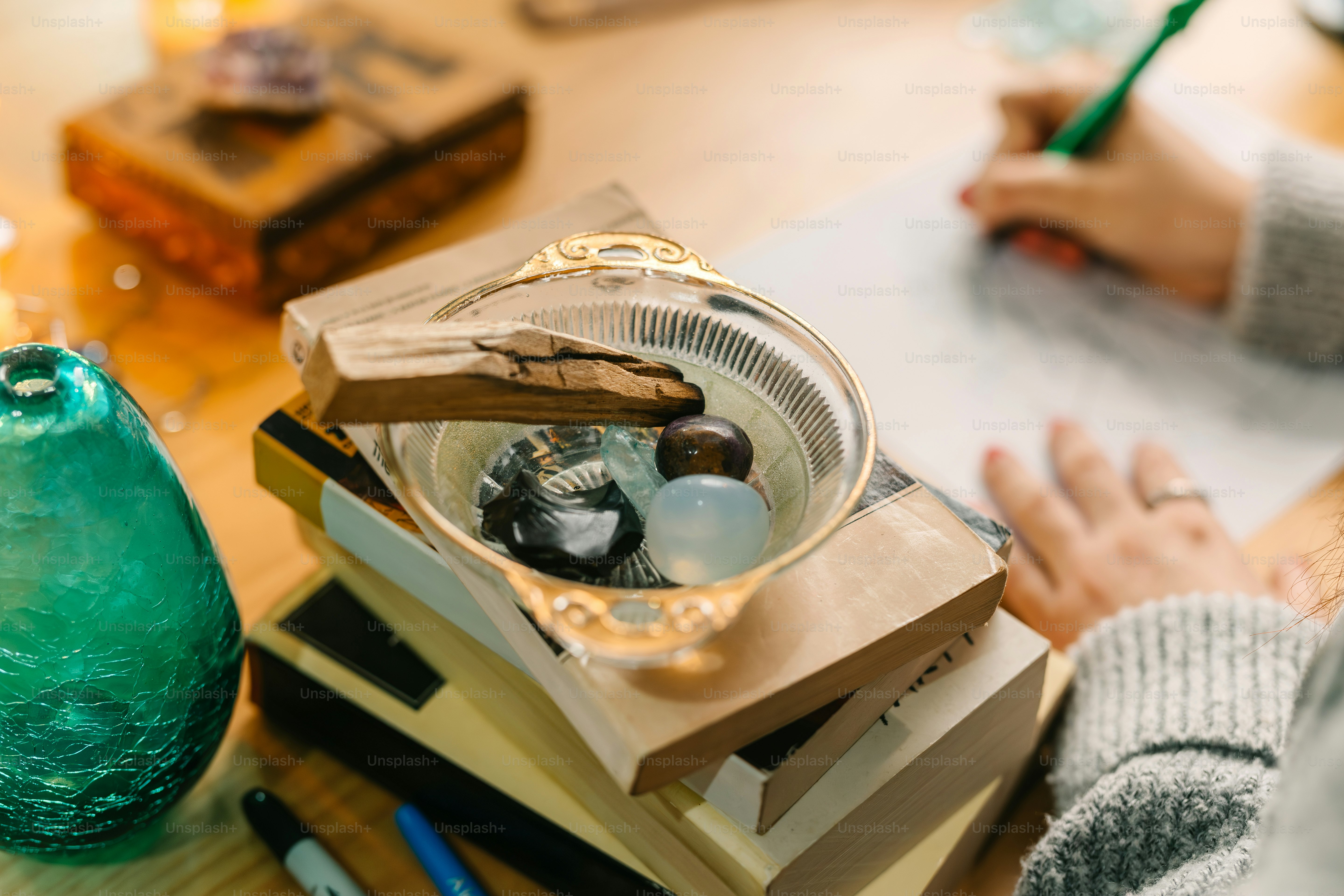 a person sitting at a table with a green vase