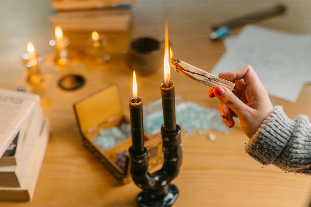 a person lighting a candle on a table