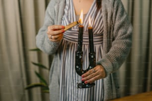 a woman holding a lit candle in her hands