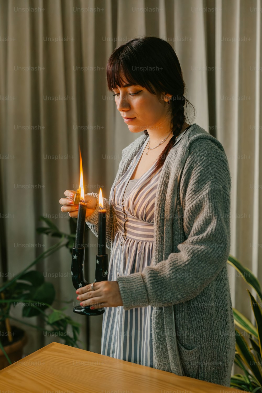 a woman holding a lit candle in her hand
