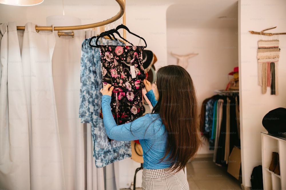 a woman looking at clothes hanging on a rack