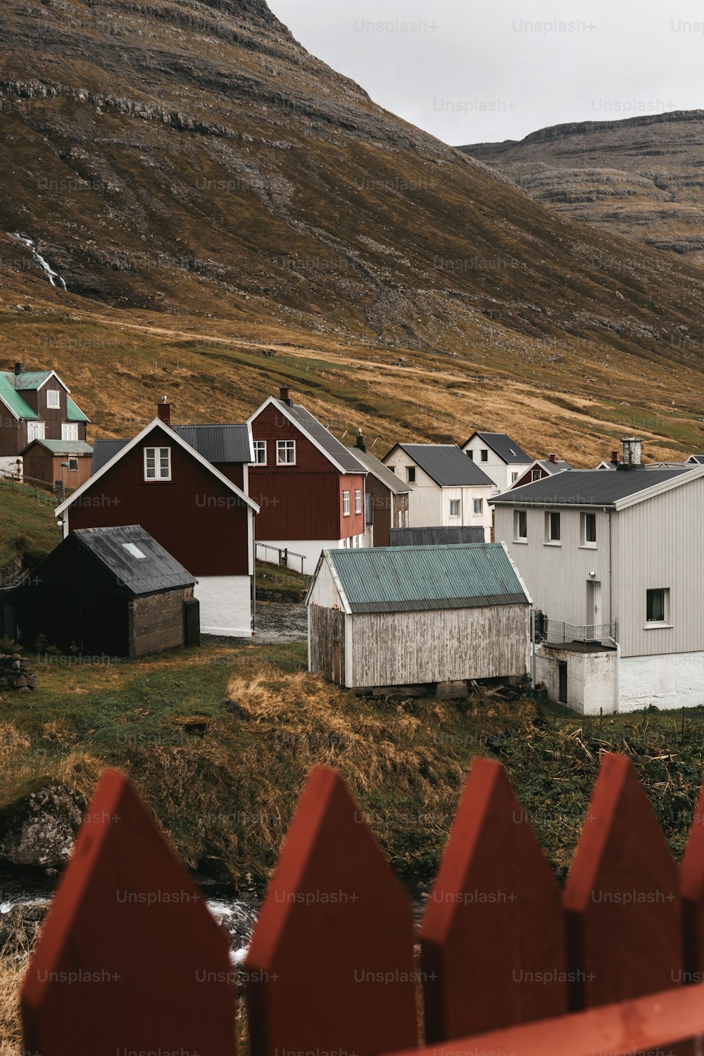 Una valla roja está frente a una hilera de casas