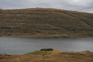 a large body of water with a hill in the background