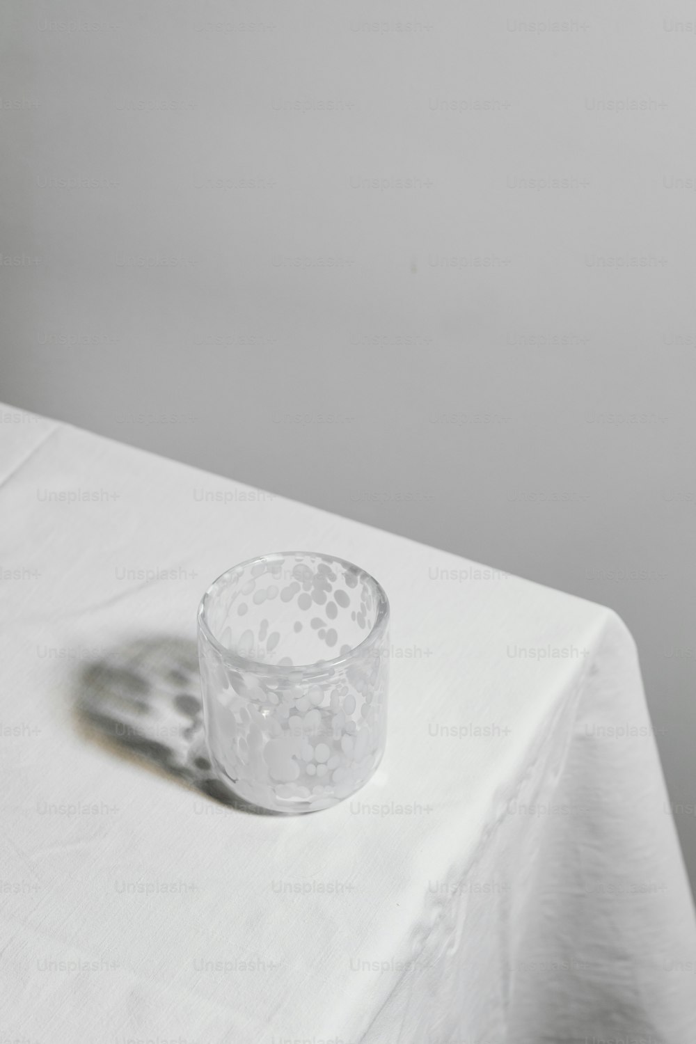 um copo sentado em cima de uma mesa branca