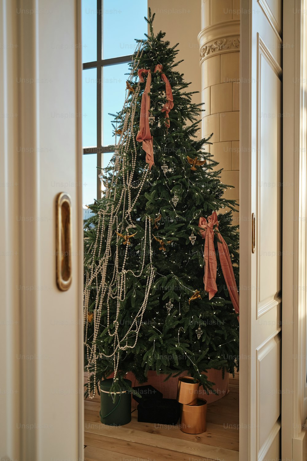 a decorated christmas tree in a doorway of a house