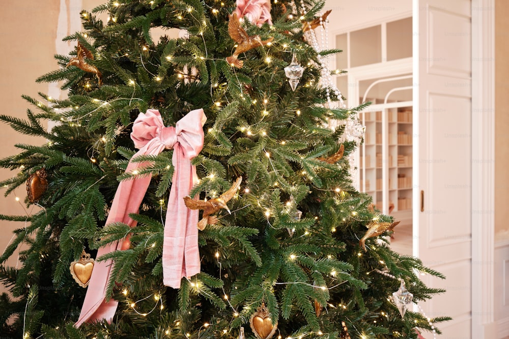 a decorated christmas tree with a pink bow