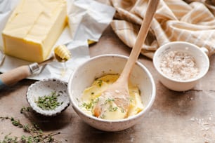 un tavolo di legno sormontato da ciotole di cibo e formaggio