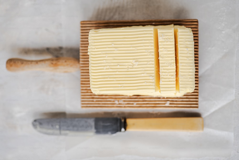 a block of butter next to a knife on a cutting board