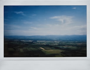 an aerial view of a field with mountains in the distance