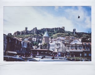uma imagem de uma cidade com um castelo no fundo