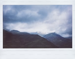 Une image d’une chaîne de montagnes sous un ciel nuageux