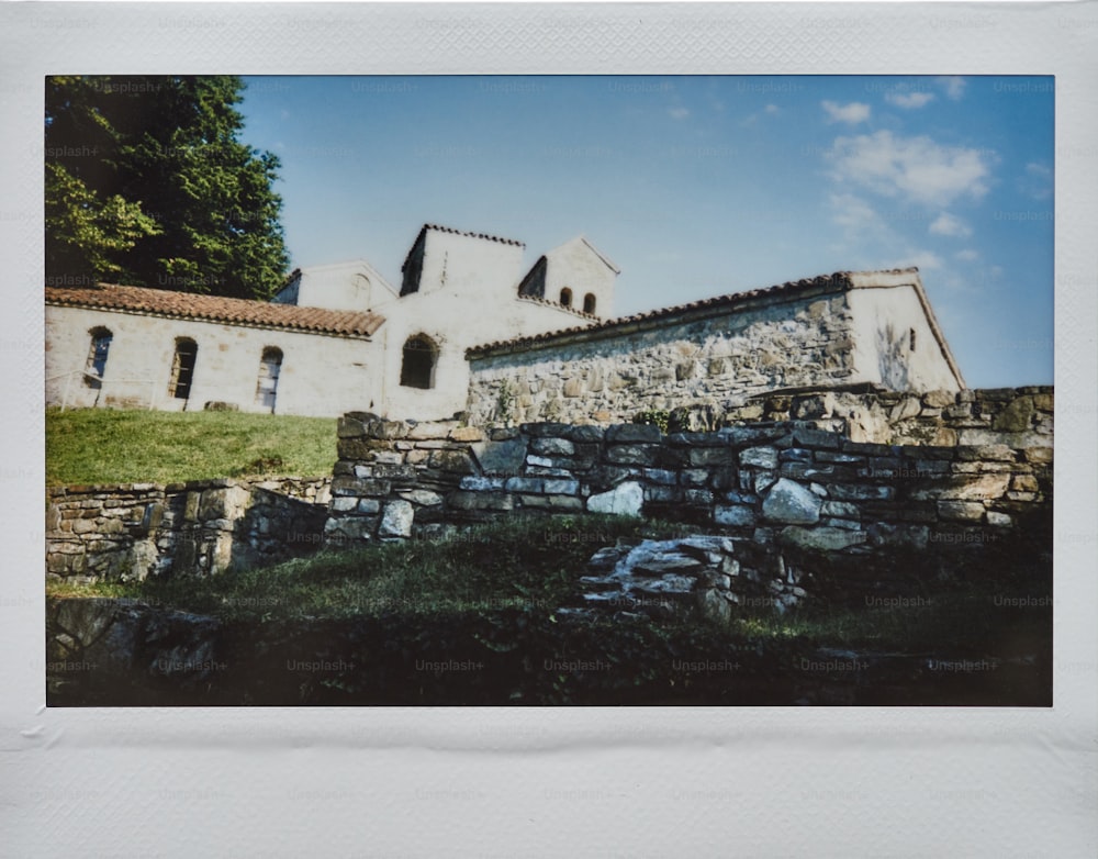 a picture of a house with a stone wall