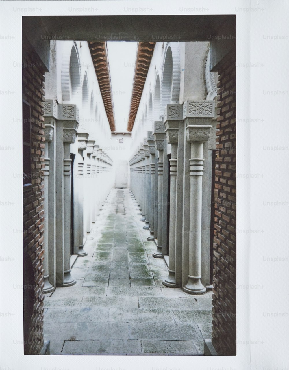 a picture of a walkway with columns and arches