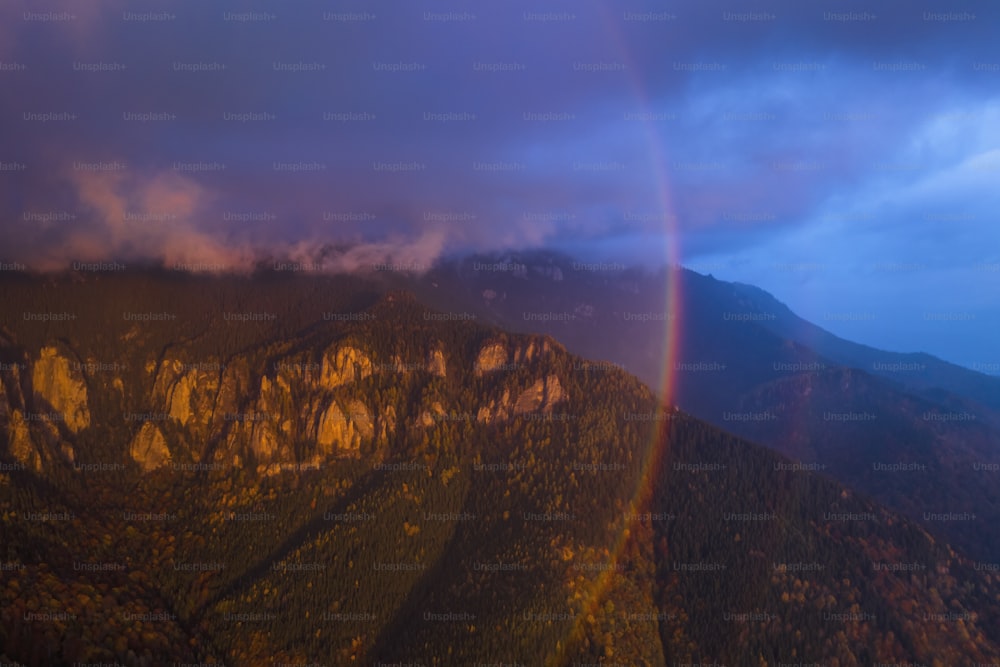 Un arco iris doble se ve sobre una cadena montañosa