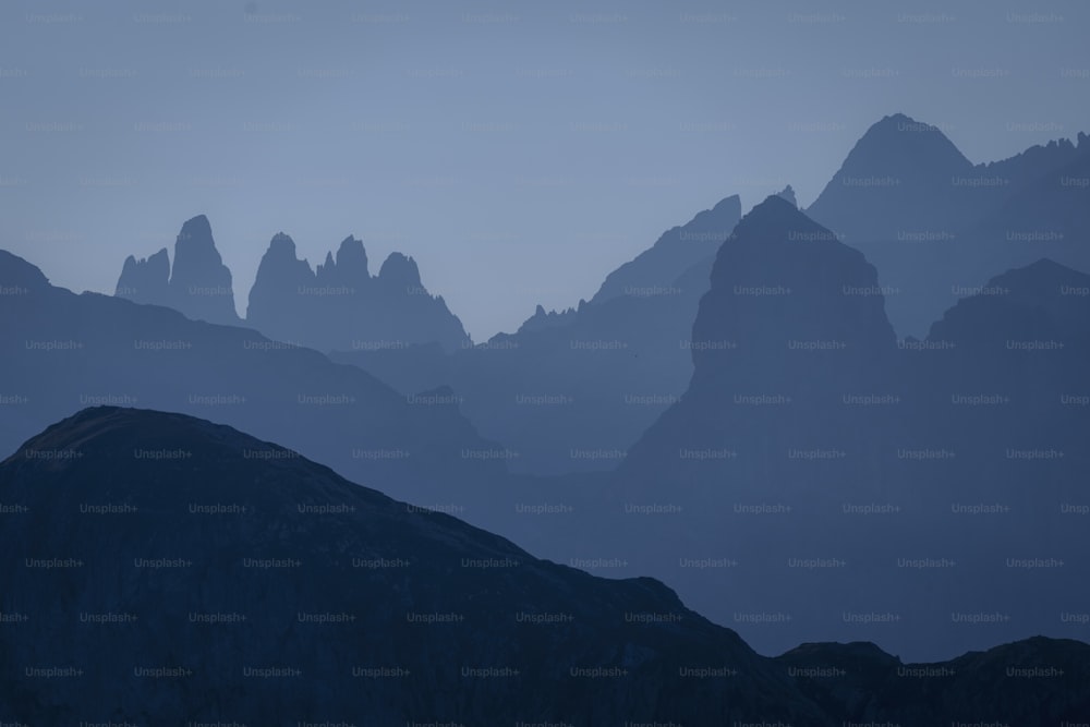 un gruppo di montagne in lontananza con un cielo blu