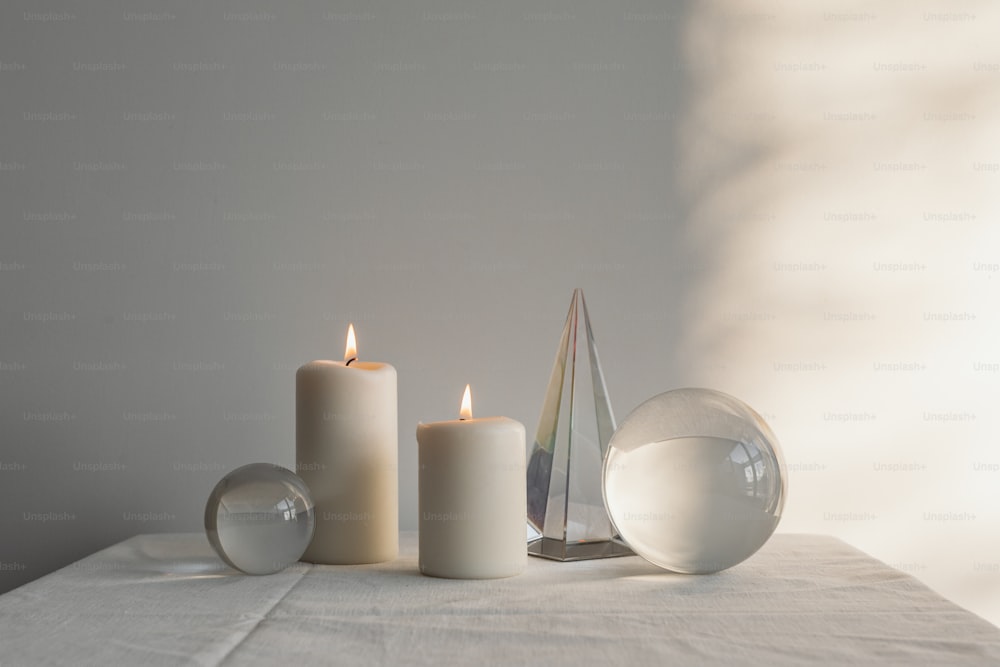 a white table topped with three white candles