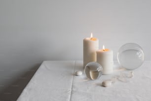 a white table topped with two white candles