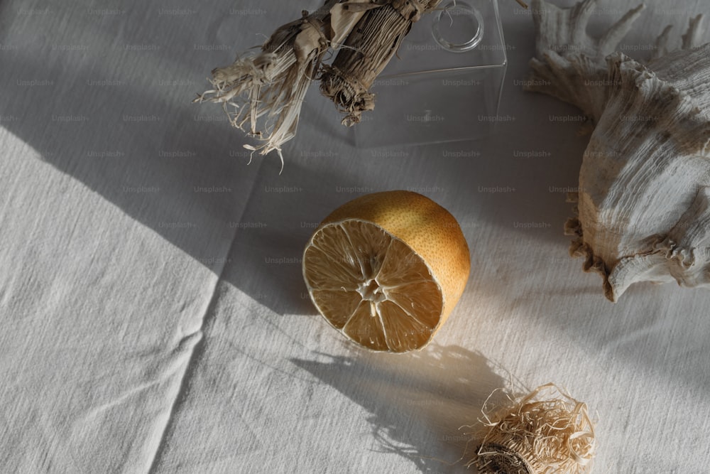 a piece of orange sitting on top of a white table cloth