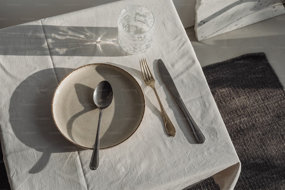 una mesa con mantel blanco y cubiertos